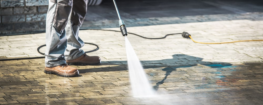 man pressure washing a driveway in Lincoln