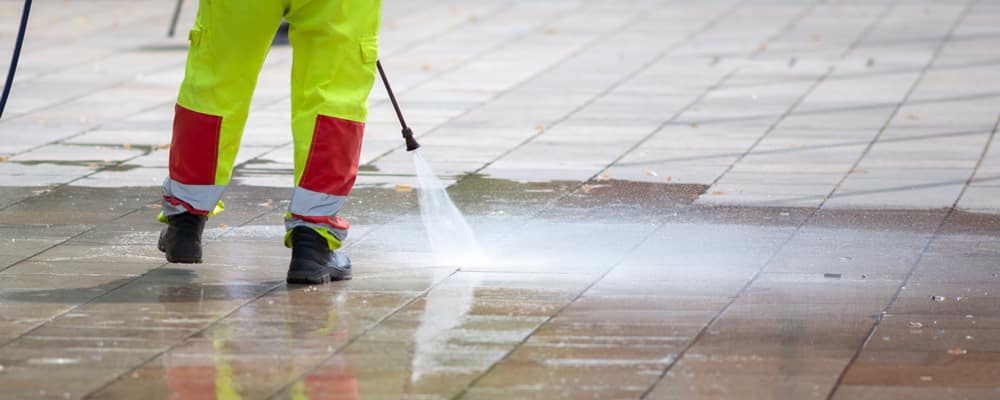 removing gum from the concrete with a pressure washer